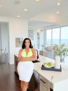 Real Estate Broker April Hunter, founder and owner of Hunter International Realty, wearing a white dress, pictured for the launch of her Sports & Entertainment Division