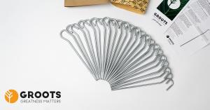 Set of 30 Groots steel tent pegs arranged in a fan pattern with kraft paper packaging and branded instruction materials