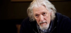 CLANCY BROWN as Riz the Director