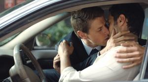 Two men kissing in a car