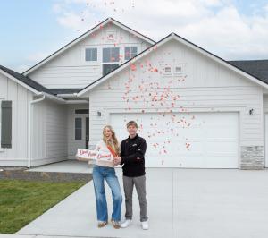 Two happy homeowners popping confetti in front of their new CBH home in celebration on closing day