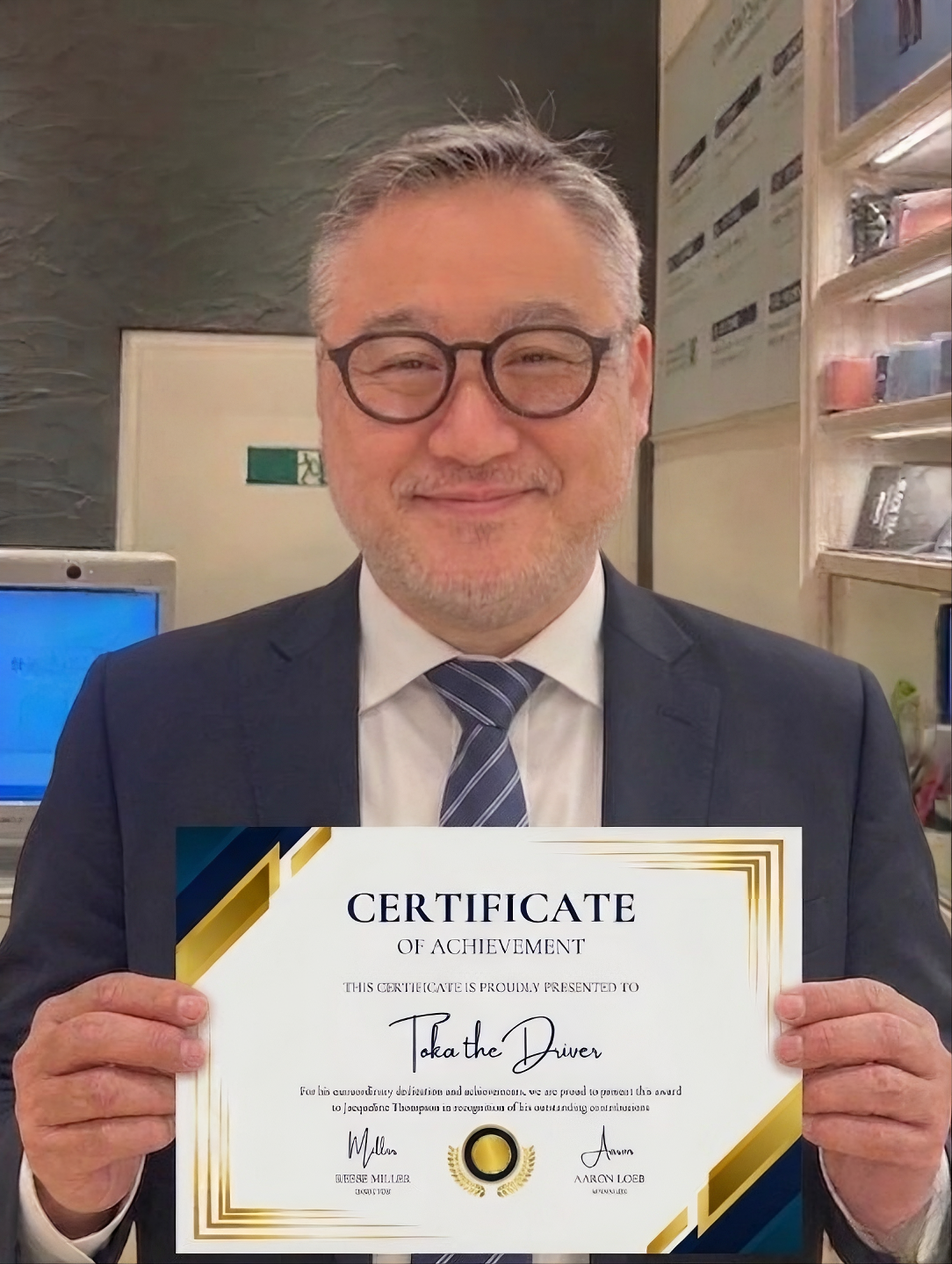 A portrait of TOKA the Driver smiling and holding a framed certificate of completion for his 100-Song Project, marking the successful end of his 100-day musical challenge.