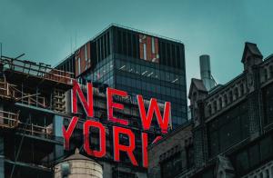 Iconic “New York” sign on an urban building facade symbolizing the city’s identity and creative landscape.