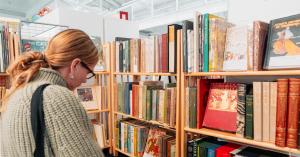 A woman looks at books on a shelf at the Manhattan Rare Book and Fine Press Fair