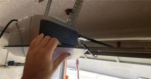 A wall-mounted LiftMaster Jackshaft opener being synchronized to a smart home hub in a Pasadena garage.