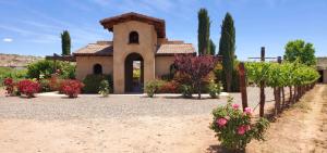 Entrance building at Alcantara Vineyards surrounded by flowers and vineyard rows
