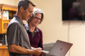 Aaron Walksler and Hope Kenoyer reviewing content together on a laptop in an office