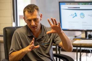 Aaron Walksler speaking and gesturing during a discussion in an office setting