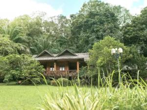 Residentiële behandelomgeving van Siam Rehab in Thailand met houten bungalow omringd door natuur en groene tuin