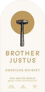 New Brother Justus Whiskey label featuring blacksmith’s hammer in front of a simple circle of light; also includes its new American Whiskey designation