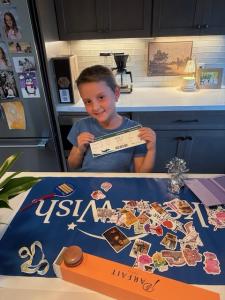 Little girl smiling and holding an airplane ticket