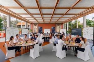 Professionals participating in a collaborative workshop with group discussions and planning boards at The Summer Social