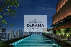 The rooftop infinity pool at DeRAMA Singapore at night, overlooking a glittering city skyline with ambient pool lighting and a row of lounge chairs under umbrellas.