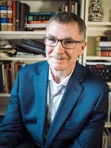 Image of author Jeff Wright, a smiling middle-aged man with short greying hair and wearing glasses.