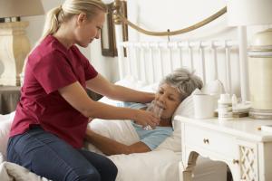 photo of a client in palliative care with a nurses aide providing assistance