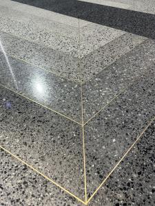 close up of finished terrazzo with brass strips and Venetian-style aggregates