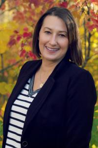 Brooke Palkie, a woman in a black blazer and striped shirt