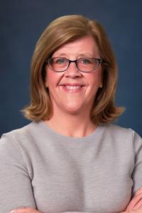 Kathryn Murphy, a woman in a grey sweater wearing glasses