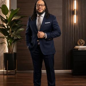 Photo of Maurice W. Evans standing in a suit inside an office