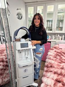 Luann Ferry Smith standing with the Glacē by Candela hydrodermabrasion device at Skin Studio 57 in Woburn, Massachusetts.