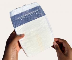 Close-up of Arsahd premium baby diaper held in hands, designed for fast absorption and to help keep moisture away from sensitive skin.