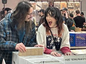 A man and woman look at records with happy looks on their faces