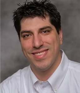 Headshot of Dr. Renaldo smiling against a neutral background