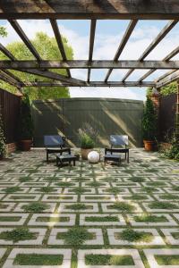 Patio combining Techo-Bloc Aquastorm permeable pavers in a geometric pattern with Westmount pavers in Merlot, featuring greenery and a compact seating area.