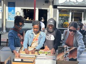 A group of people looking at records outdoors.