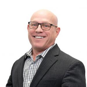 Image of a man in a suit smiling