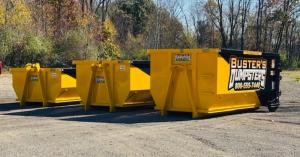 Three Buster's Dumpsters roll-off dumpsters in 10 yard 15 yard and 20 yard sizes lined up at the company yard in Jackson MI