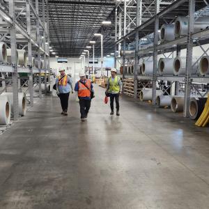 IntelliSystems team members walking through a manufacturers facility. DoD contractors and subcontractors face loss of contracts or face steep fines without accurate CMMC 2.0 compliance.