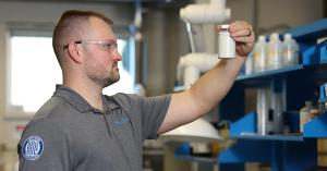 Boll-certified Trucent technician examining a fluid sample during laboratory analysis.