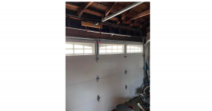 Garage door technician installing heavy-duty 7x19 stainless steel aircraft cables on a residential garage door in Pasadena zip code 91105.