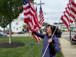 A volunteer installs flags in Milford, Massachusetts