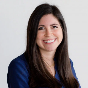 A photo of a smiling woman wearing a blue shirt.
