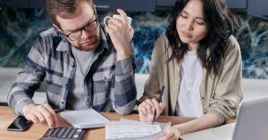a man and woman review their electricity bill and budget