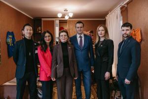 Six people standing together inside the Empty Beds installation at the European Parliament at the opening on April 14, 2026.