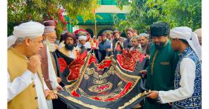 Followers carrying the ceremonial chadar to the darbar of Hazrat El Sheikh Gillani