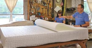 Bedmakers at The Beloit Mattress Company placing a foam layer by hand on a mattress in the factory