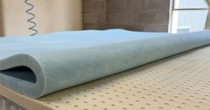 Foam comfort layer rolled back over a latex mattress layer during production