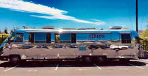 A large polished Silver Bullet Airstream trailer parked outdoors, featuring a mirrored aluminum exterior and branded signage, used for experiential marketing and mobile brand activations.