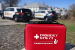 Emergency Birth Kits with police cruisers in background.