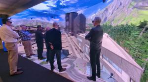 people standing inside a 3D virtual reality room with a seamless curved screen, floor, and ceiling display looking at a virtual city
