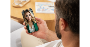 A man is having a real time video call with a professional woman and holding a mobile phone in his hand.