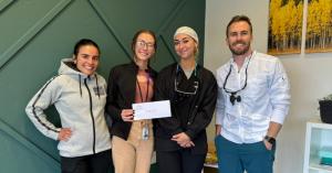 Dr. McKay Butler, family and cosmetic dentist in Longmont, CO, presenting a check to LEVI