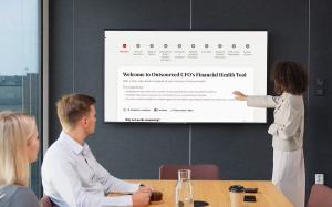 Business professionals reviewing Outsourced CFO’s Financial Health Tool on a presentation screen during a meeting