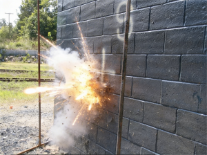 Controlled blast test on a polyurea-coated concrete masonry unit wall — live detonation at the University of Missouri Explosives Laboratory demonstrating ArmorThane blast mitigation performance