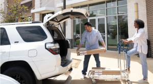 A couple picking up an IKEA order from a pick-up location and loading it in their car