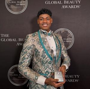 Mykhael Michaels, founder of Mrs. Earth, holding the Best Director | Producer Under 25" award at the Global Beauty Awards at the Seattle Marriott Bellevue